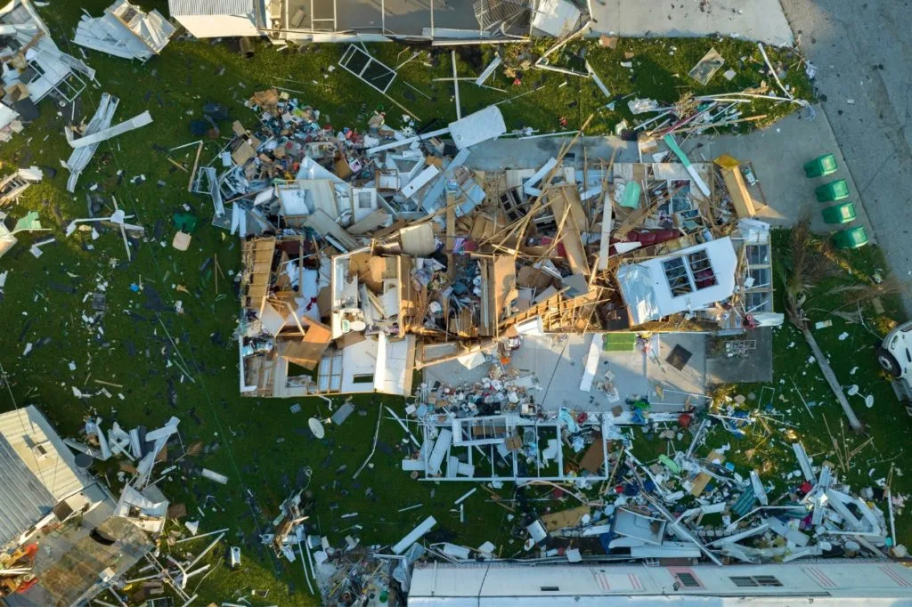 Use of cargo drones in humanitarian aid: Top-down aerial view of a severely damaged building and surrounding debris following a disaster, highlighting humanitarian aid scenarios.