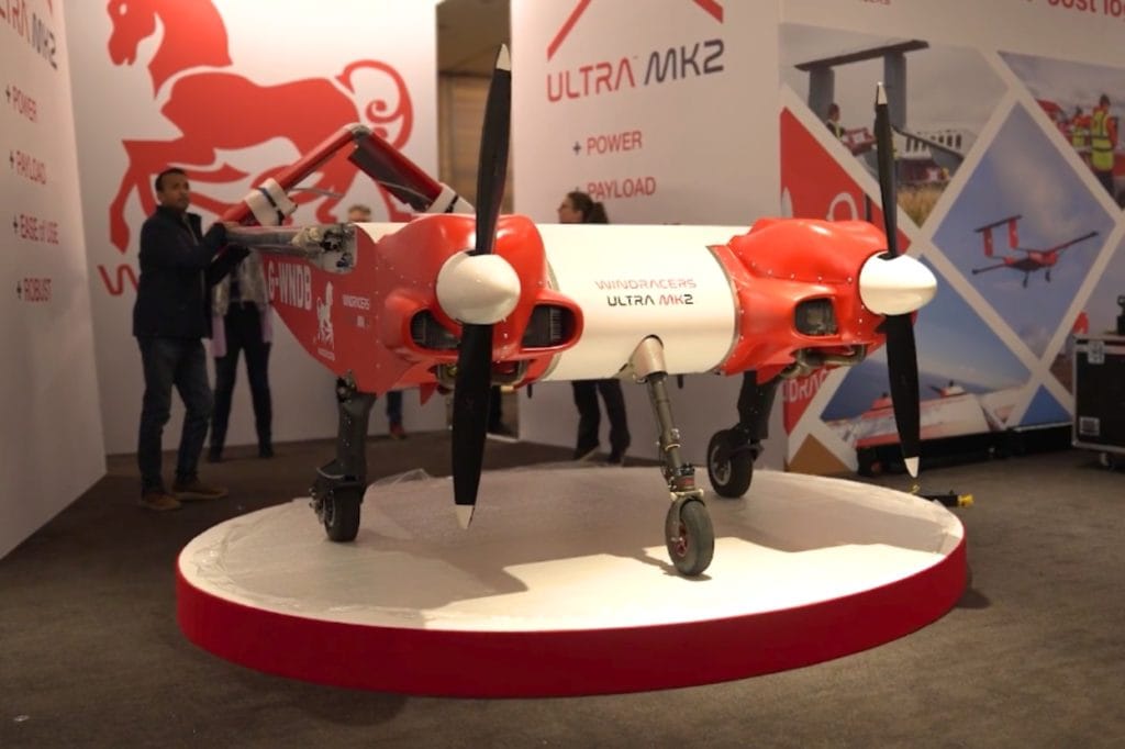 Windracers Heavy-lift logistics drones: Windracers ULTRA MK2 heavy-lift cargo drone displayed on a stand at an exhibition, showing twin propellers, landing gear, and branded livery.