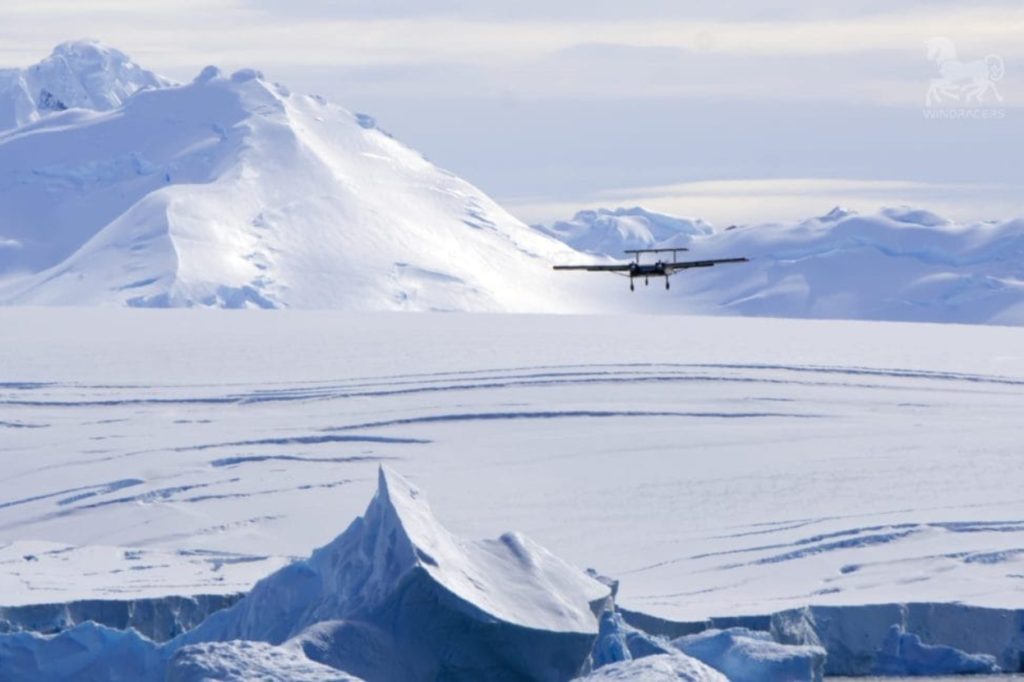 Long-distance drones: Fixed-wing drone flying over snow-covered polar landscape.