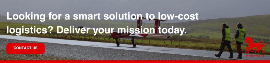 Looking for a smart solution to low-cost logistics_ Deliver your mission today: Red cargo drone taxiing on rural runway with personnel and promotional banner.